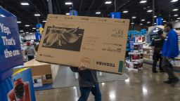 A shopper carries a Toshiba television inside a Best Buy store on Black Friday in Union City, California, US, on Friday, Nov. 24, 2023. An estimated 182 million people are planning to shop from Thanksgiving Day through Cyber Monday, the most since 2017, according to the National Retail Federation.