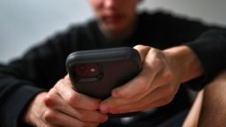 A teenager uses his mobile phone to access social media, in Sydney, Australia, on November 13, 2024.